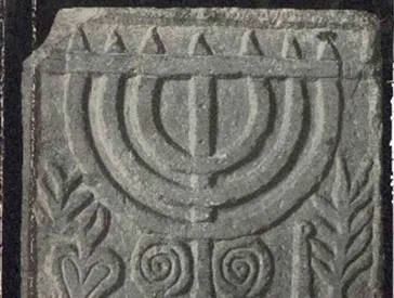 Detail aus einem Buchcover: Abbildung eines Menora-Steinreliefs