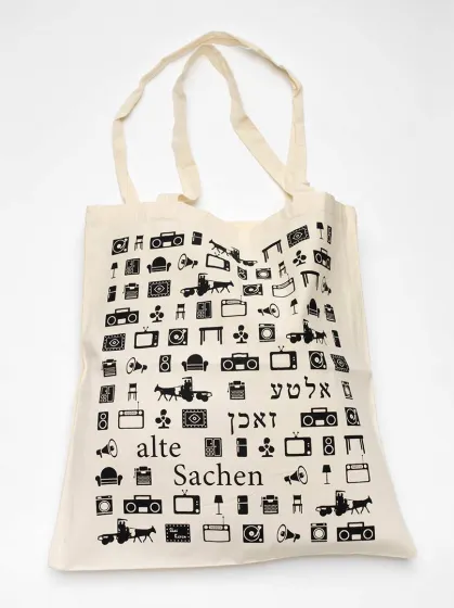 Leinenbeutel mit Piktogrammen von Möbeln, Kassettenrecordern, Megaphonen, Pferdekutschen u.a. und der Aufschrift »Alte Sachen«